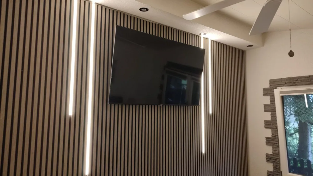 Wand mit Akustik-Holzlamellen und senkrechtem LED-Lichtelement